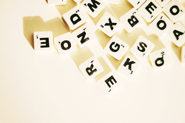 Scrabble tiles scattered on a white surface, creating space for text or design.